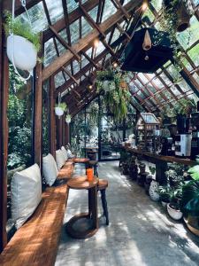 a greenhouse with tables and potted plants in it at Ngeeb bed and EV station in Chiang Rai