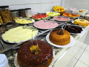 a buffet with many different types of cakes and pastries at Pousada Santa Gianna in Aparecida