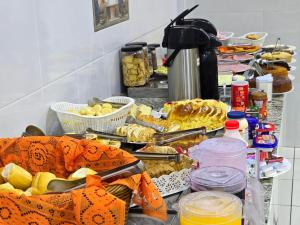 a buffet of food on a counter in a kitchen at Pousada Santa Gianna in Aparecida