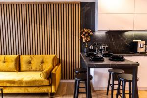 佐托爾的住宿－Forest 47 by Housine，厨房配有黄色的沙发和带凳子的桌子