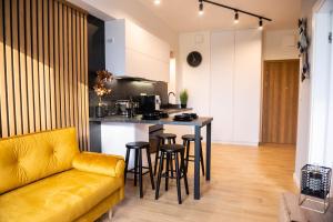 a kitchen with a couch and a table with stools at Forest 47 by Housine in Zator