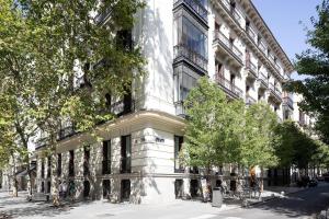 een wit gebouw met bomen ervoor bij Apartamentos Blume Conde Aranda in Madrid