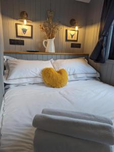 un osito de peluche sentado encima de una cama en Rusty Duck Retreat Shepherds Hut, en Shedfield