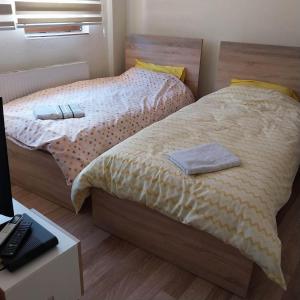 a bedroom with two beds and a desk with a keyboard at Zezo Apartments in Bitola
