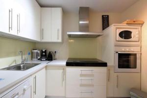 uma cozinha com armários brancos e um lavatório em Apartamento Golf Lujo Mor 2, Valle del Este Vera em Vera