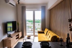 a living room with a yellow couch and a television at Forest 47 by Housine in Zator