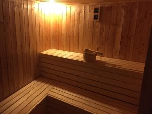 a wooden sauna with a bucket on a shelf at Wellness Hotel Várfal in Pécs
