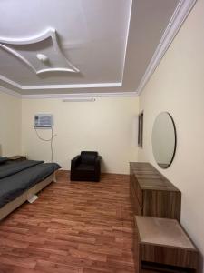 Schlafzimmer mit einem Bett und einem Wandspiegel in der Unterkunft Al-mohamdiah apartments in Mekka