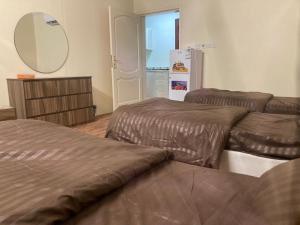 a room with two beds and a mirror and a refrigerator at Al-mohamdiah apartments in Makkah