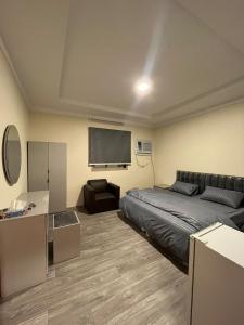 Schlafzimmer mit einem Bett und einem Flachbild-TV in der Unterkunft Al-mohamdiah apartments in Mekka