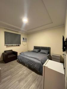 ein Schlafzimmer mit einem Bett und einem großen Bildschirm in der Unterkunft Al-mohamdiah apartments in Mekka