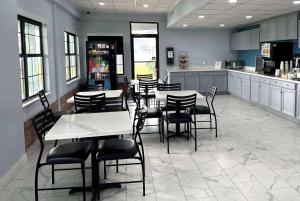 a restaurant with tables and chairs and a kitchen at Days Inn by Wyndham Lake Charles in Lake Charles