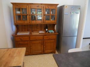 una cucina con grande mobile in legno accanto a un frigorifero di Villa catalane avec grand jardin, au calme, mer et montagne a Sorède