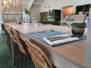 a long wooden table with a glass of wine on it at Ibis Styles Lisieux Normandie in Lisieux