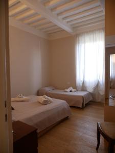 Dos camas en una habitación con ventana. en Appartamento Vissi D'Arte, en Lucca