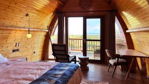 セレンゲティ国立公園にあるSerengeti Ark Safari Lodge - Kogatendeのベッドルーム(ベッド1台、テーブル付)、バルコニーが備わります。