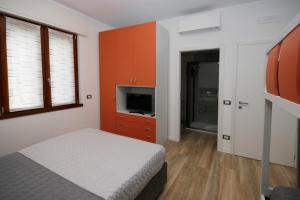 1 dormitorio con 1 cama y TV en B&B Boccaleone, en Bérgamo