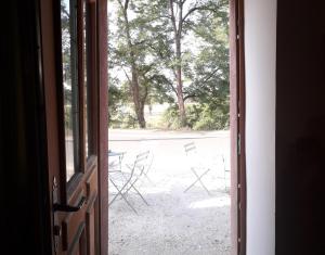 an open door leading to a yard with chairs at Chambre double in Vallon-en-Sully