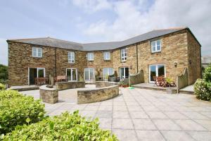 an exterior view of a brick house with a patio at Two Bedroomed Holiday Cottage with Sea Views in St Austell