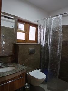 ein Bad mit einer Dusche, einem WC und einem Waschbecken in der Unterkunft Kidar in Leh