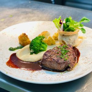 a plate of food with meat and vegetables on a table at Landhotel Restaurant Hubinger in Thörl