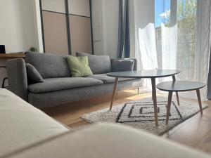 a living room with a couch and two tables at Appartement Élégant Central - Parking Inclus in Manosque