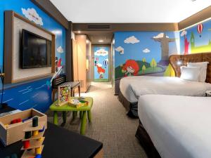 a hotel room with two beds and a tv and a room with two beds at Pullman Sao Paulo Guarulhos Airport in Guarulhos