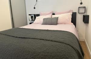 a bedroom with a large bed with pink and white pillows at Le Havre Provençal - Parking Inclus in Manosque