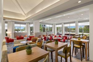 a restaurant with tables and chairs and windows at Hilton Garden Inn Atlanta East/Stonecrest in Lithonia