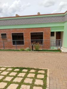 a brick building with two windows and a balcony at KIM UNIVERSITY TWO ROOMS APARTMENT in Kigali