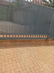 a bench sitting next to a metal fence at KIM UNIVERSITY TWO ROOMS APARTMENT in Kigali