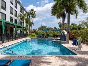 een zwembad in een hotel met palmbomen bij Hampton Inn West Palm Beach-Florida Turnpike in West Palm Beach