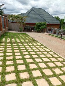 een bakstenen tuin met gras en een gebouw bij KIM UNIVERSITY TWO ROOMS APARTMENT in Kigali