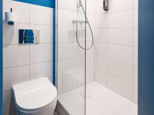 een badkamer met een douche en een toilet bij ibis budget Mâcon Nord in Mâcon