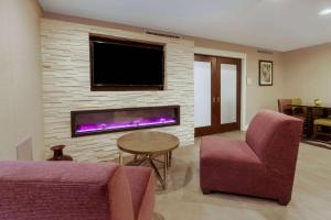 sala de estar con chimenea y TV en La Quinta by Wyndham Detroit Utica, en Utica