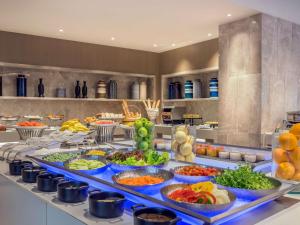 a buffet with many bowls of food on a table at Novotel Phuket City Phokeethra in Phuket Town