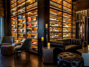 a wine tasting room with couches and a wine cellar at Novotel Phuket City Phokeethra in Phuket Town
