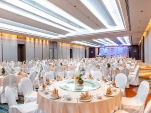 a large banquet hall with white tables and white chairs at Novotel Phuket City Phokeethra in Phuket Town