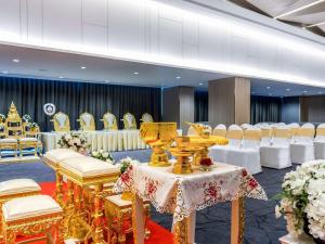 a banquet hall with white chairs and a table with a table at Novotel Phuket City Phokeethra in Phuket Town