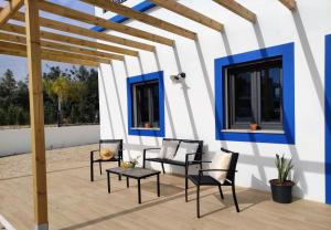 a patio with chairs and tables and blue and white walls at Casa do Belé in Faro