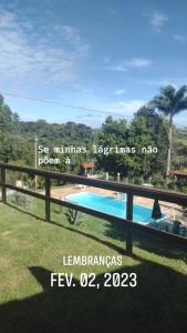 a sign on a fence next to a swimming pool at Chácara pedacinho do céu in Socorro