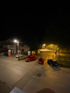 un parcheggio notturno con auto parcheggiate in esso di Play Apartman Obrenovac a Obrenovac