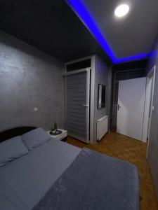 a bedroom with a bed and a blue light at Play Apartman Obrenovac in Obrenovac