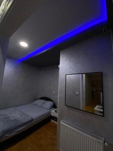 una camera con letto e luce blu di Play Apartman Obrenovac a Obrenovac