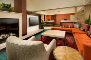 a living room with orange furniture and a fireplace at Residence Inn Atlanta NE/Duluth Sugarloaf in Duluth
