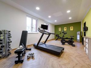 einen Fitnessraum mit mehreren Trainingsgeräten in einem Raum in der Unterkunft ibis Styles Aschaffenburg in Aschaffenburg