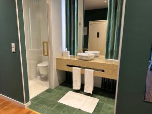 a bathroom with a sink and a mirror at Solar dos Cantos Botanic House & Garden in Ponta Delgada