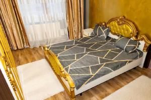 a bedroom with a bed with a gold frame at Central Apartment ressidence city in Bucharest