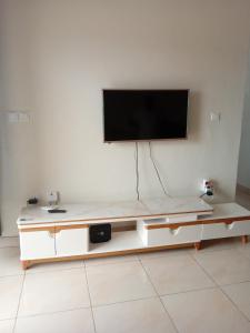 a living room with a tv on a white wall at KIM UNIVERSITY TWO ROOMS APARTMENT in Kigali