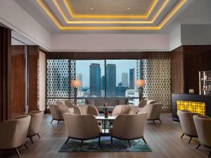 a lobby with chairs and a table and a large window at Raffles Jakarta in Jakarta